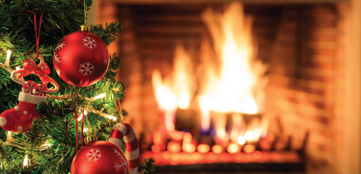 Fire safety Tip for the holiday season. Image of a Fireplace with fire burning and a Christmas tree with ornaments.